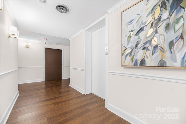 corridor featuring baseboards, wood finished floors, and crown molding