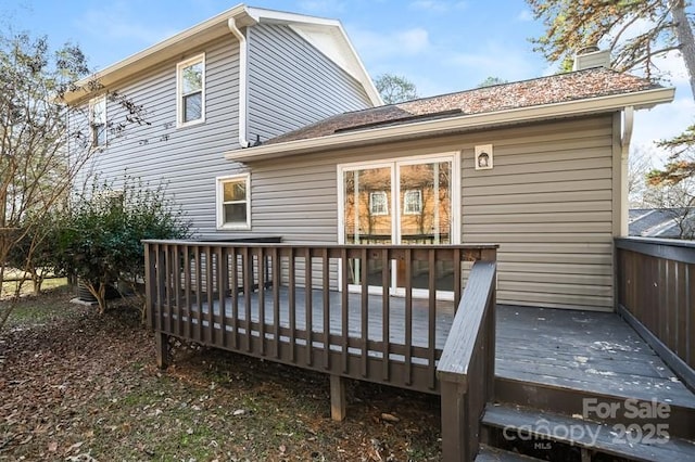 rear view of house featuring a chimney and a deck