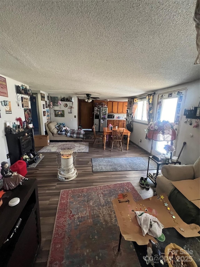 living area with a textured ceiling, ceiling fan, and wood finished floors