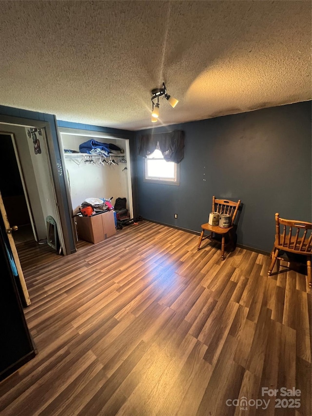 interior space featuring a textured ceiling and wood finished floors