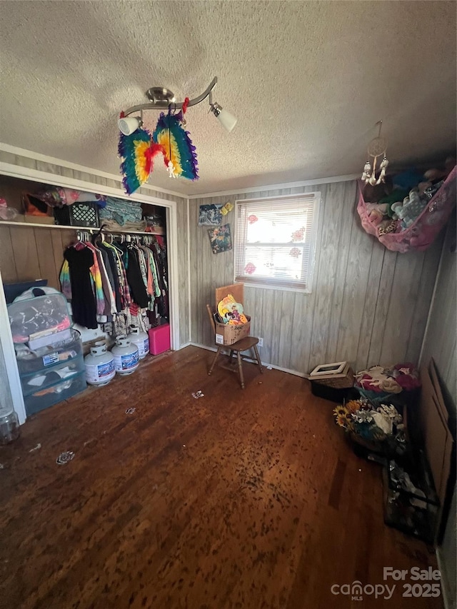 bedroom with a textured ceiling, a closet, and wood finished floors