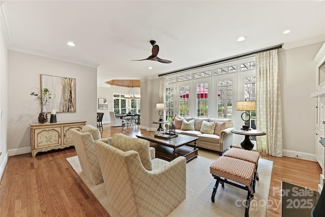 living room with wood finished floors, baseboards, and ornamental molding