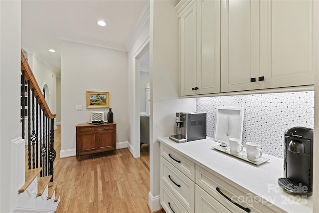 kitchen featuring backsplash, crown molding, light wood-type flooring, and light countertops