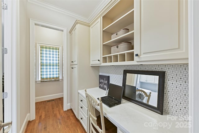 office area featuring visible vents, baseboards, crown molding, and light wood-style floors