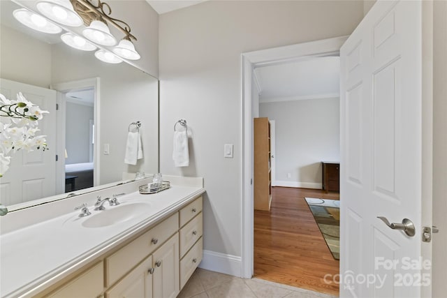 bathroom with baseboards, ornamental molding, vanity, and tile patterned flooring