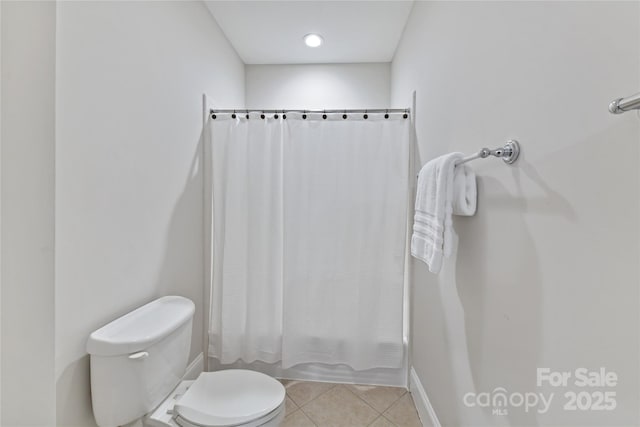 bathroom featuring tile patterned flooring, toilet, and shower / tub combo