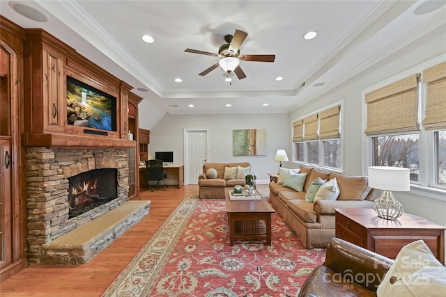 living room featuring a raised ceiling, crown molding, recessed lighting, and light wood-style floors