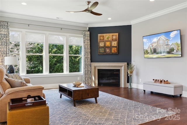 living room featuring baseboards, a glass covered fireplace, wood finished floors, and crown molding