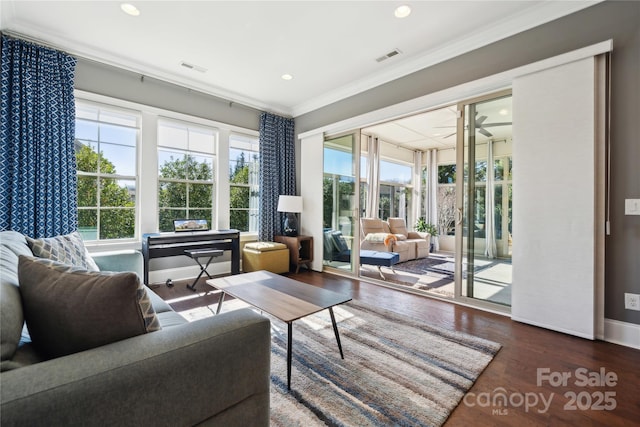 living area with recessed lighting, visible vents, ornamental molding, wood finished floors, and baseboards