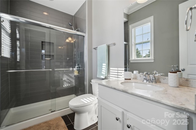 full bath with a stall shower, tile patterned flooring, vanity, and toilet