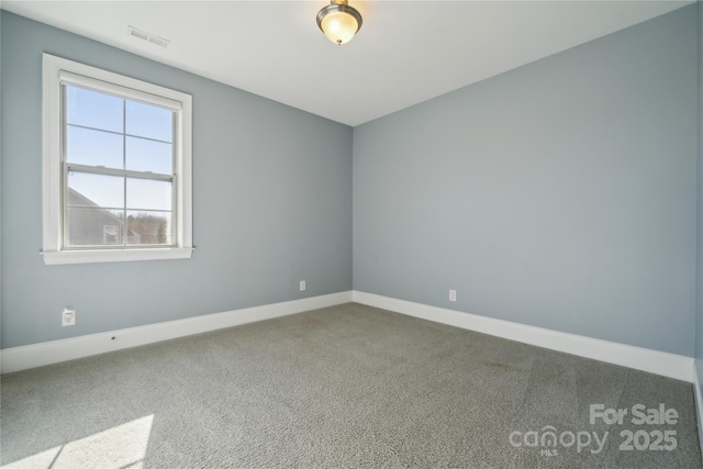 carpeted spare room featuring baseboards