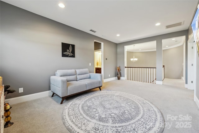 living area with visible vents, a chandelier, and carpet flooring