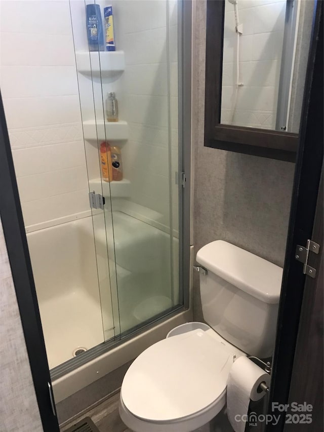 full bathroom with a shower stall and toilet