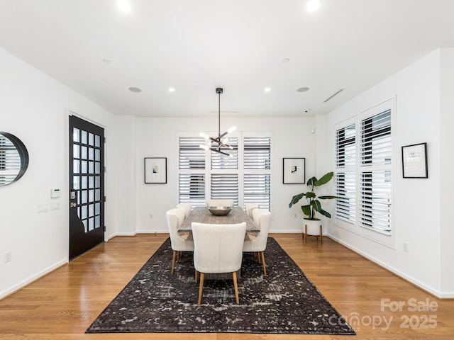 dining space with a chandelier, recessed lighting, baseboards, and light wood-style floors