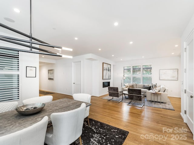 dining space with baseboards, wood finished floors, and recessed lighting