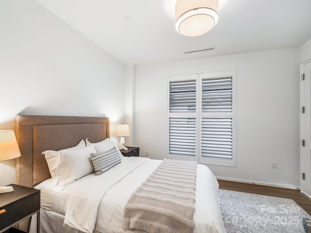 bedroom featuring baseboards and wood finished floors