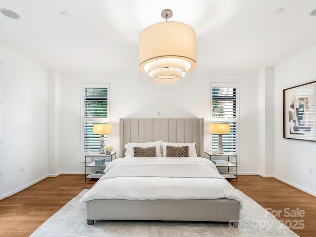 bedroom with wood finished floors and baseboards