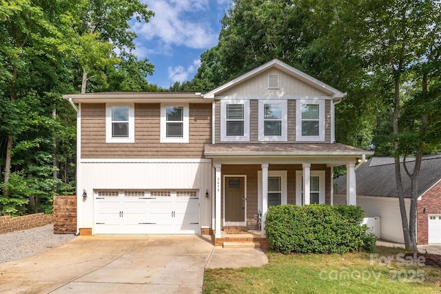 view of front of property with a garage, concrete driveway, and covered porch