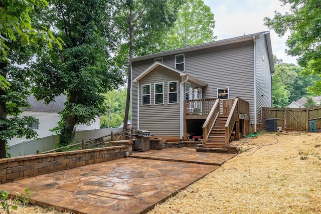 rear view of property featuring stairs, fence, a deck, and a patio