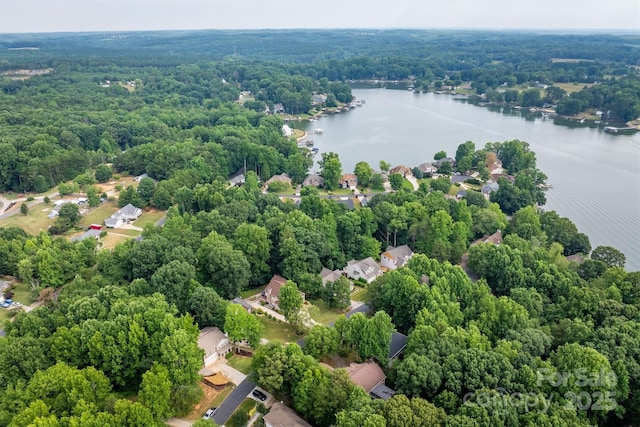 drone / aerial view featuring a water view and a wooded view