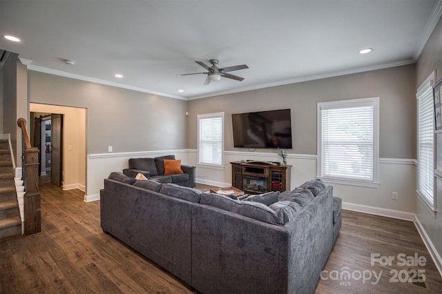 living area with dark wood-style floors, stairway, a wealth of natural light, and crown molding