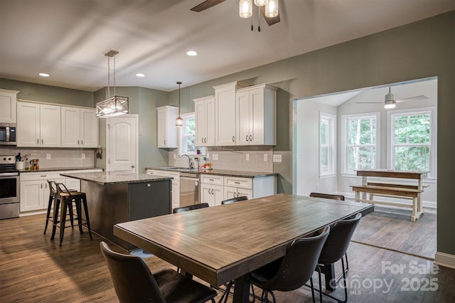 kitchen featuring appliances with stainless steel finishes, a center island, white cabinetry, and dark wood finished floors