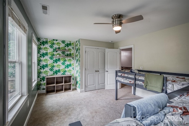 interior space with ceiling fan, carpet flooring, visible vents, baseboards, and wallpapered walls