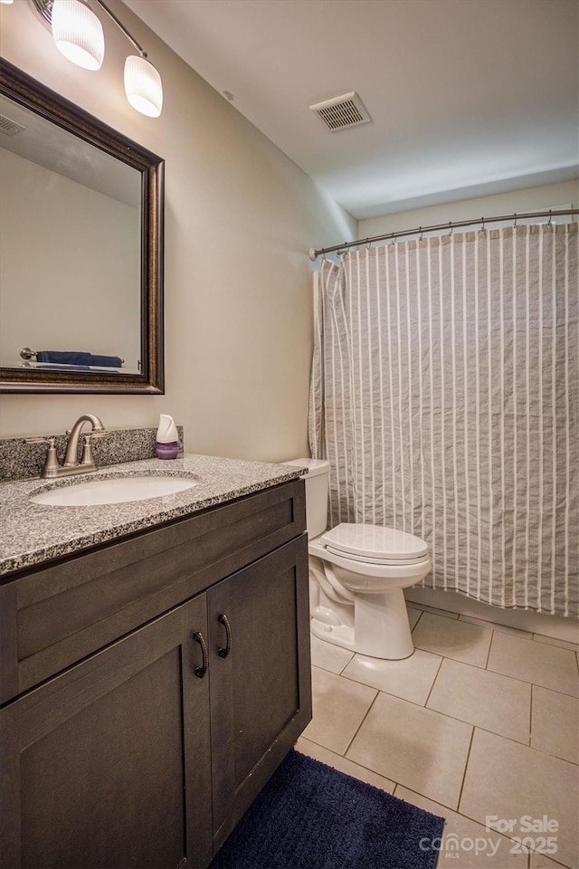 bathroom with visible vents, vanity, toilet, and tile patterned floors