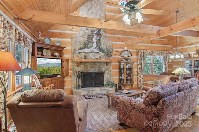 living area featuring vaulted ceiling with beams, a stone fireplace, wood finished floors, wooden ceiling, and ceiling fan with notable chandelier