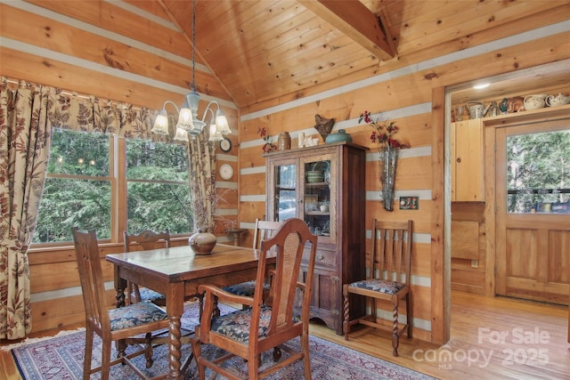 dining space with a chandelier, lofted ceiling, a wealth of natural light, and light wood-style flooring