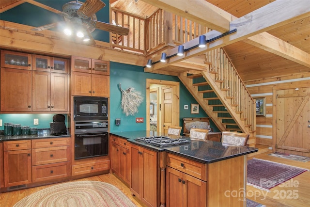 kitchen featuring a ceiling fan, beam ceiling, light wood finished floors, and black appliances