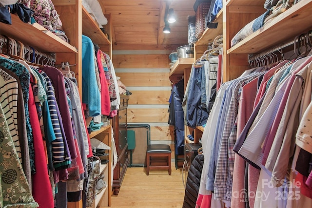 walk in closet with wood finished floors