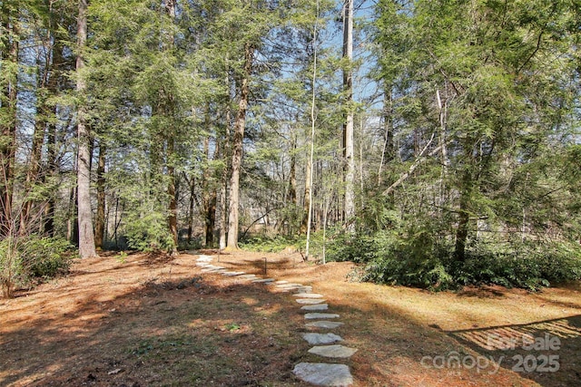 view of yard with a view of trees