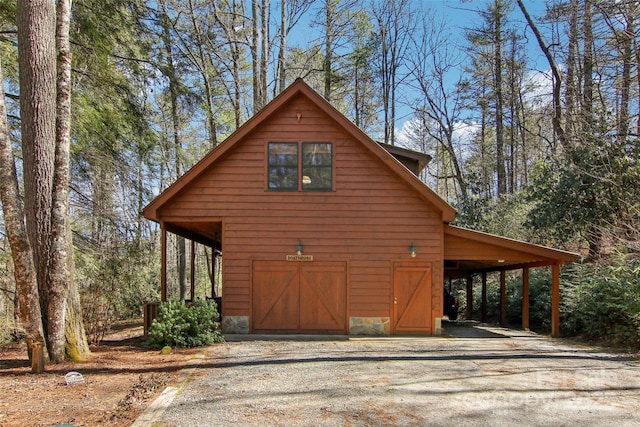 view of side of home with an outbuilding, driveway, and a barn