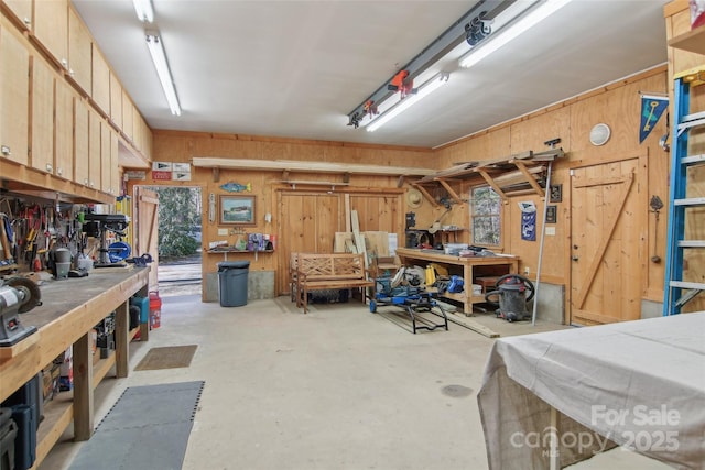 garage featuring wooden walls and a workshop area