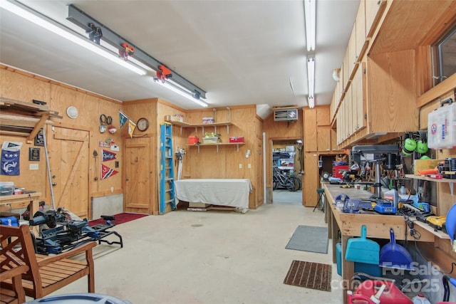 garage featuring wood walls and a workshop area