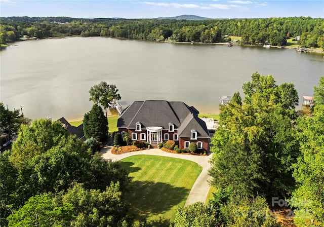 birds eye view of property with a water view and a wooded view