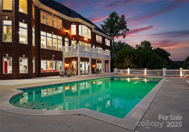 view of swimming pool featuring fence, a fenced in pool, and a patio