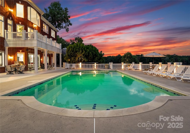 view of swimming pool featuring fence, a fenced in pool, and a patio