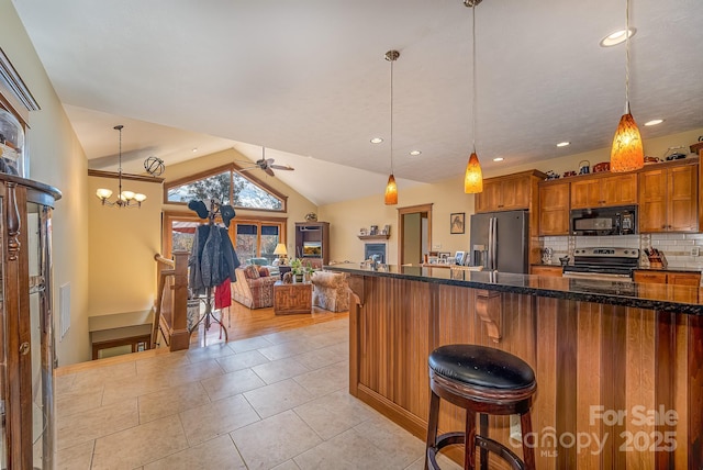 kitchen with stainless steel appliances, a kitchen breakfast bar, vaulted ceiling, decorative backsplash, and brown cabinetry