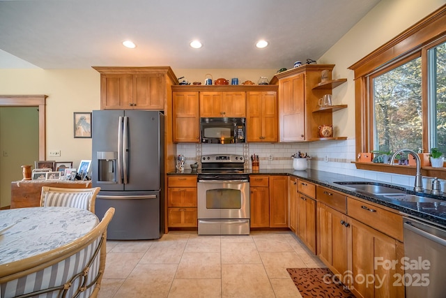 kitchen with brown cabinets, open shelves, stainless steel appliances, decorative backsplash, and a sink