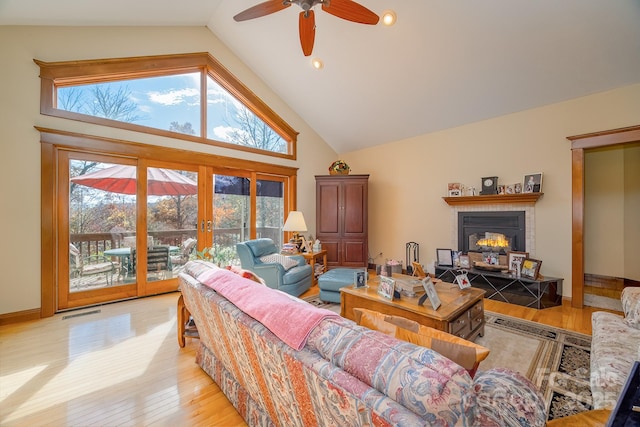 living room featuring french doors, light wood finished floors, visible vents, high vaulted ceiling, and baseboards