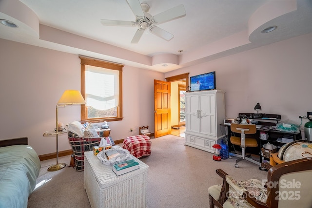 interior space with baseboards, a raised ceiling, and a ceiling fan