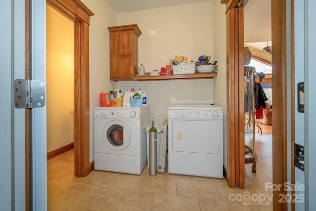 laundry area with cabinet space, light tile patterned flooring, and washing machine and clothes dryer