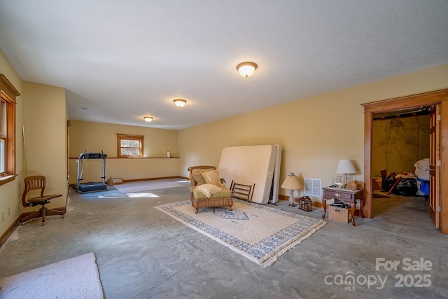 sitting room with baseboards, visible vents, and unfinished concrete floors