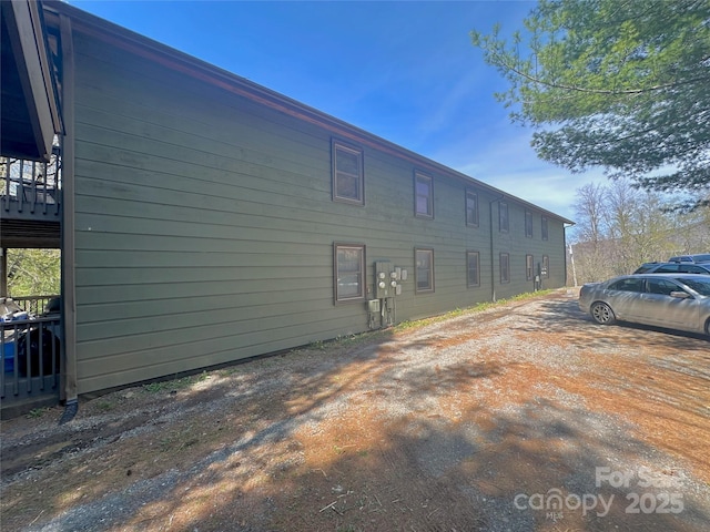 view of side of home with dirt driveway