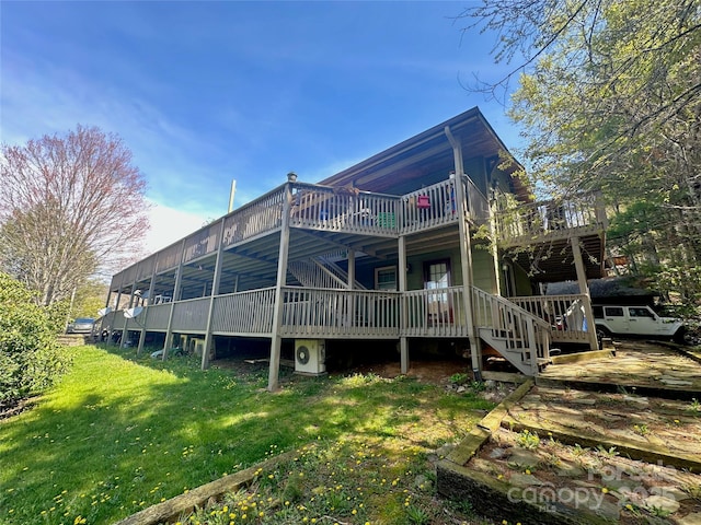 back of property featuring a deck, a yard, and stairway