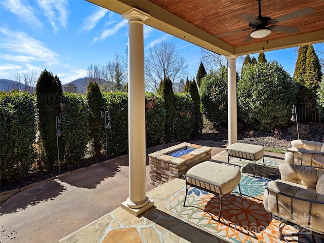 view of patio / terrace with a fire pit, ceiling fan, and fence