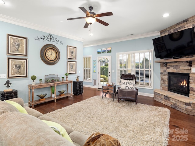 living room featuring dark wood-style flooring, a fireplace, crown molding, and baseboards