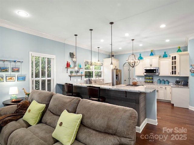 kitchen featuring dark wood finished floors, stainless steel appliances, glass insert cabinets, open floor plan, and a healthy amount of sunlight